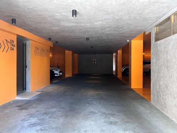 A parking garage with orange walls and a concrete floor. - Flat Quality Comfort CoHouse - Tambaú (João Pessoa)
