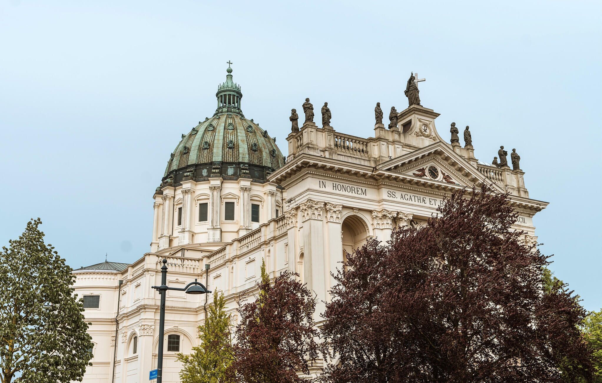 A large, ornate building with a prominent dome and statues on the roof.