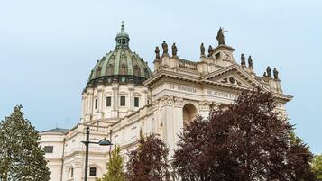 A large, ornate building with a prominent dome and statues on the roof.