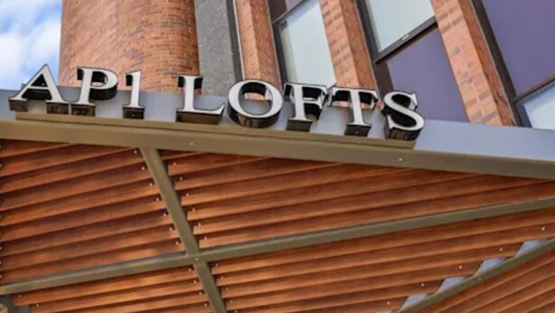 L'esterno di un edificio con un cartello che riporta la scritta 'API LOFTS'.