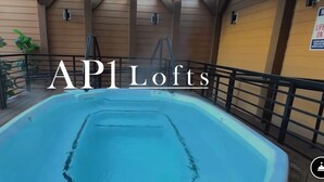 Una piscina interna con un pontile in legno e ringhiere metalliche.