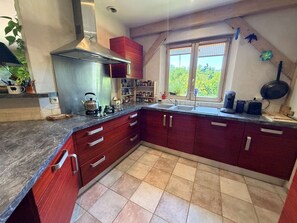 A modern kitchen with a gas stove, double sink, and a window with a view of greenery. - La maison du Dolmen 4 or 6 p with private swimming pool (LE BUISSON DE CADOUIN)