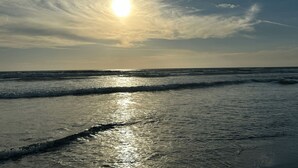 Una playa con el sol reflejándose en el agua.