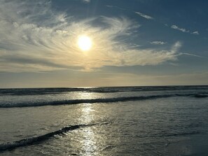 En strand med solens refleksioner i vandet.