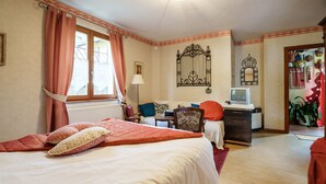 A bedroom with a bed, a desk, a chair, a radiator, and a television. - Sévilla Guest Room in Boersch with Garden View (Boersch)