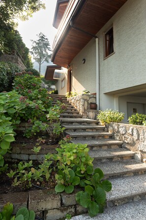 Eine Steintreppe führt zu einem Gebäude mit einem Holzdach und einer Steinmauer.