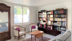 A living room with a large bookshelf, two armchairs, a wooden coffee table, and a sofa. - Bénodet - 150 m from the beach, restaurants and thalasso centre (BENODET)