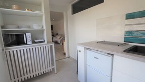 A compact kitchen with white cabinetry, a built-in microwave, a mini fridge, and a sink. - Bénodet - 150 m from the beach, restaurants and thalasso centre (BENODET)