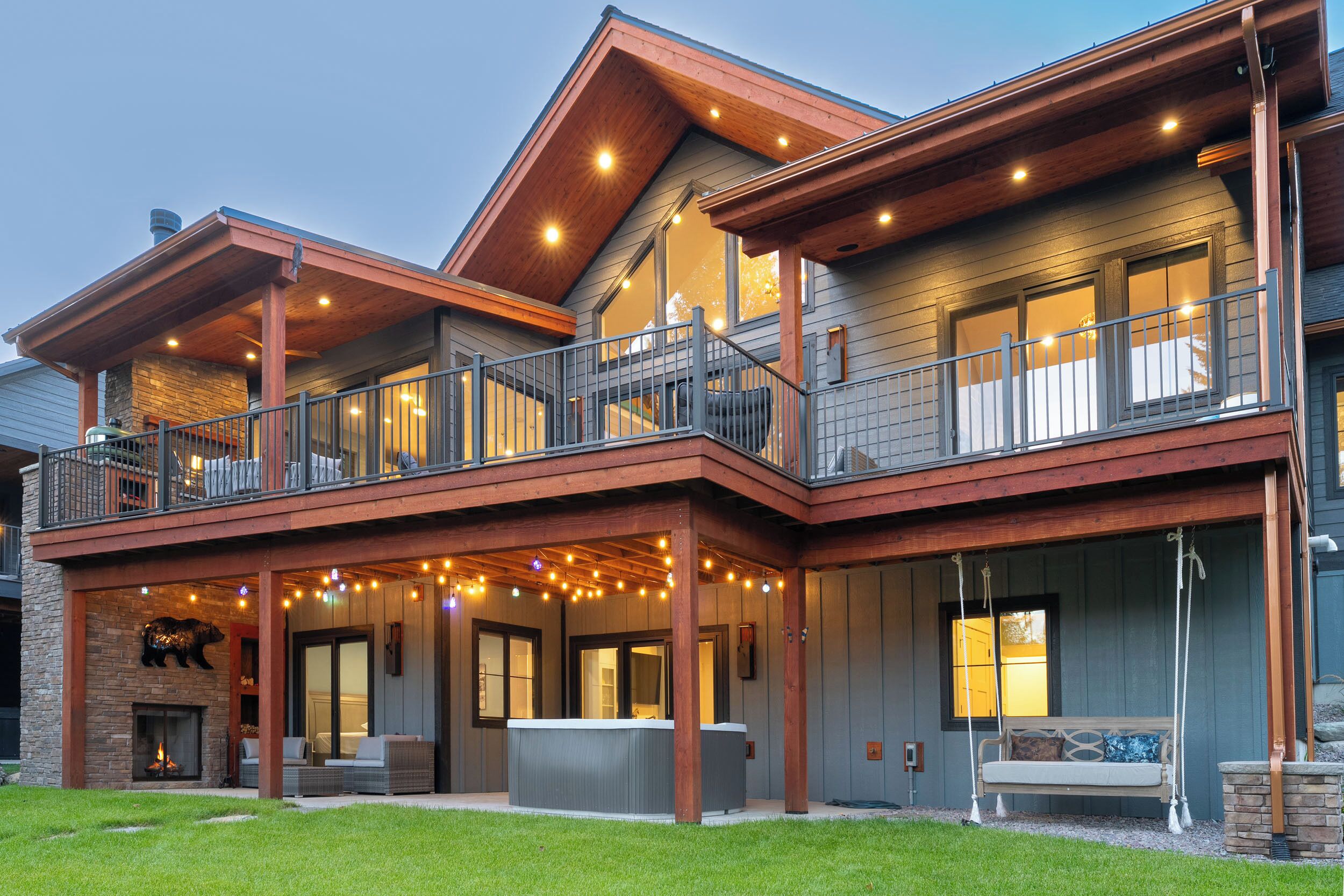 A two-story house with a balcony, a fireplace, and outdoor seating.