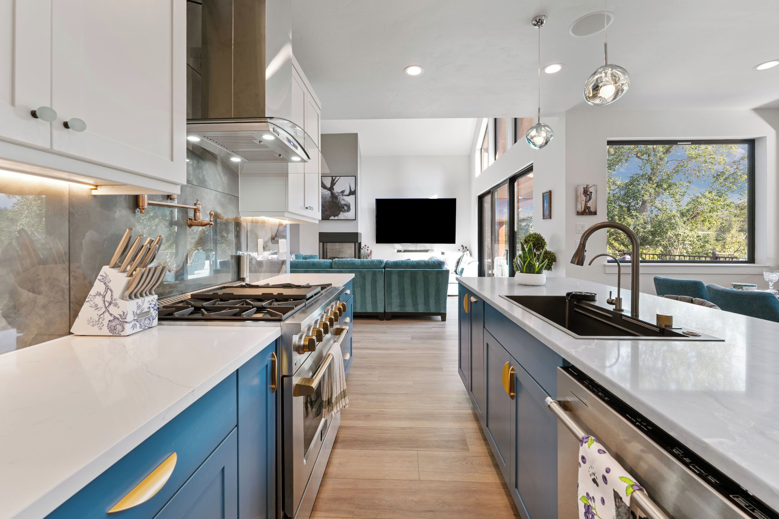 A modern kitchen with a central island, built-in oven, and a large window.