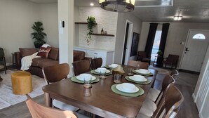 Een eethoek met een houten tafel gedekt voor zes personen, omringd door beklede stoelen in bruin.