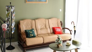 A living room with a beige sofa, a small round coffee table, and a painting on the wall. - Résidence Soavina (Antananarivo)