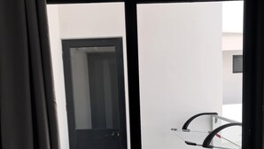 Un appartement moderne doté d’une porte-fenêtre coulissante donnant sur un balcon.