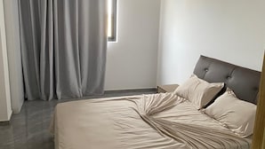 Une chambre à coucher avec un lit, des rideaux et une fenêtre.