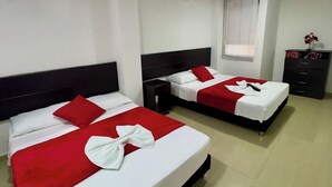 A hotel room with two beds, each with red and white bedding, a small nightstand, a dresser, and a window with blinds. - Hotel Blue Santa Rosa de Cabal (Santa Rosa de Cabal)