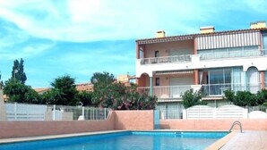 A rectangular swimming pool with a tiled edge, surrounded by a paved area. - Lovely semi-detached villa in residence with pool near Richelieu beach, Cap d'Agde (LE CAP D AGDE)
