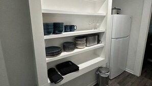 A kitchen with white cabinetry, a stainless steel trash bin, and a white refrigerator. - 85-in TV|Massage Sofa|3 KING Beds|Walk to UT: ½ mi (Austin)
