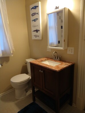 Ein Badezimmer mit Toilette, Waschbecken und einem Spiegel an der Wand.