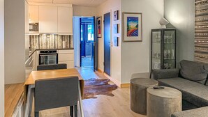 A modern living room with a wooden dining table, grey sofas, and a glass cabinet. - Amazing apartment in Bjorli with WiFi (Bjorli)