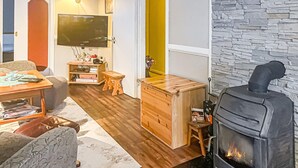 En hyggelig stue med pejs, møbler af træ og et fjernsyn.