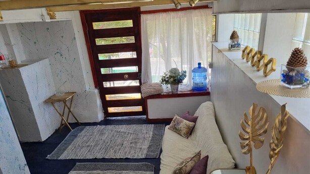 A cozy living area with a sofa, rugs, and decorative items. - Reñaca Village, in Viña del Mar, 3 min walking to beach, @casavista_panoramica (Viña del Mar)