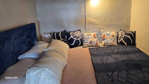A small, cozy room with a Galaxy S25 bed, a blue headboard, and a variety of patterned pillows. - Reñaca Village, in Viña del Mar, 3 min walking to beach, @casavista_panoramica (Viña del Mar)