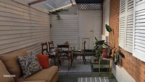 A cozy patio area with a sofa, chairs, and a small table. - Reñaca Village, in Viña del Mar, 3 min walking to beach, @casavista_panoramica (Viña del Mar)