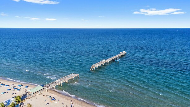 A pier extending into the sea with a beach area at the end. - Beachside Bliss • Renovated Studio • Walk to Ocean & Restaurants + Saltwater Pool (Fort Lauderdale)
