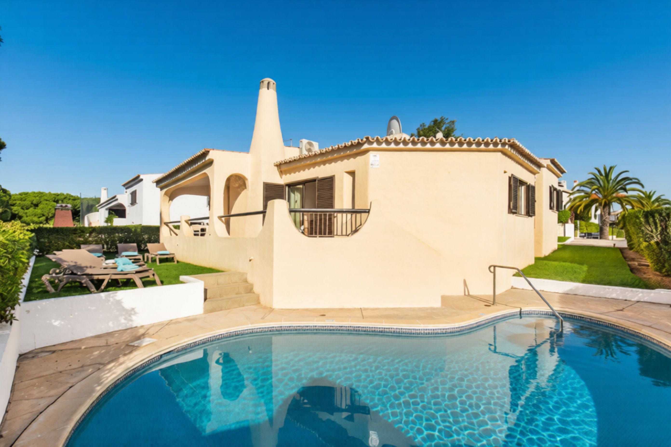 A residential property with a swimming pool, a covered patio, and a garden.