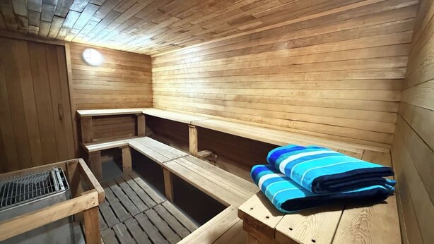 A sauna room with wooden benches and a bench with towels. - Summit View II Bed & Bath| Ski-In Hot Tub Sleeps 2 (Kimberley)