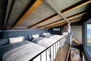 A modern interior with a high ceiling, exposed beams, and a balcony with a view. - VILLA IZU Zessei (Ito)