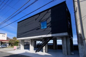 A modern building with a black facade and a blue window. - VILLA IZU Zessei (Ito)