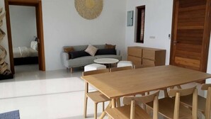 A spacious living area with a wooden dining table and chairs, a grey sofa, and a round coffee table. - Great Sea View Mountain Villa Koh Samui (Koh Samui)