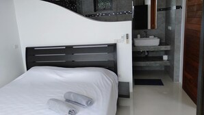 A single bed with a white mattress and a black headboard, a small bedside table, and a wall-mounted control panel. - Great Sea View Mountain Villa Koh Samui (Koh Samui)