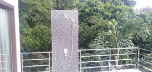 A vertical mosaic water feature on a balcony with a metal railing, surrounded by lush greenery. - Great Sea View Mountain Villa Koh Samui (Koh Samui)