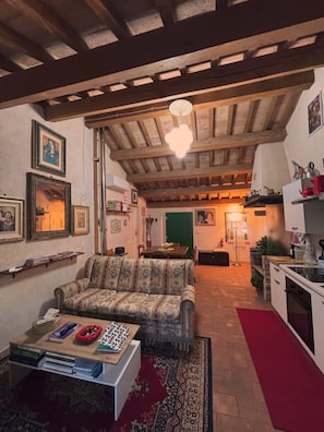 A cozy living room with a patterned sofa, a coffee table, and a red rug. - Holiday Home 'Domus Giò Giò' with Sea View, Wi-Fi, and Air Conditioning (Saludecio)