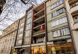 A multi-story building with a vintage shop on the ground floor, balconies, and a sign for a restyler store. - Krakowska Downtown Deluxe Apartment (Poznań)