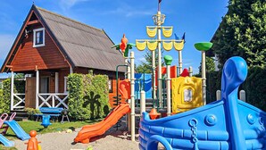 Un parque infantil con toboganes, estructuras de escalada y una zona de juegos con temática náutica.