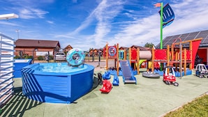 Un terrain de jeux équipé d’une piscine, de toboggans et de diverses structures ludiques.