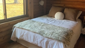 Un lit superposé avec vue sur un arbre.