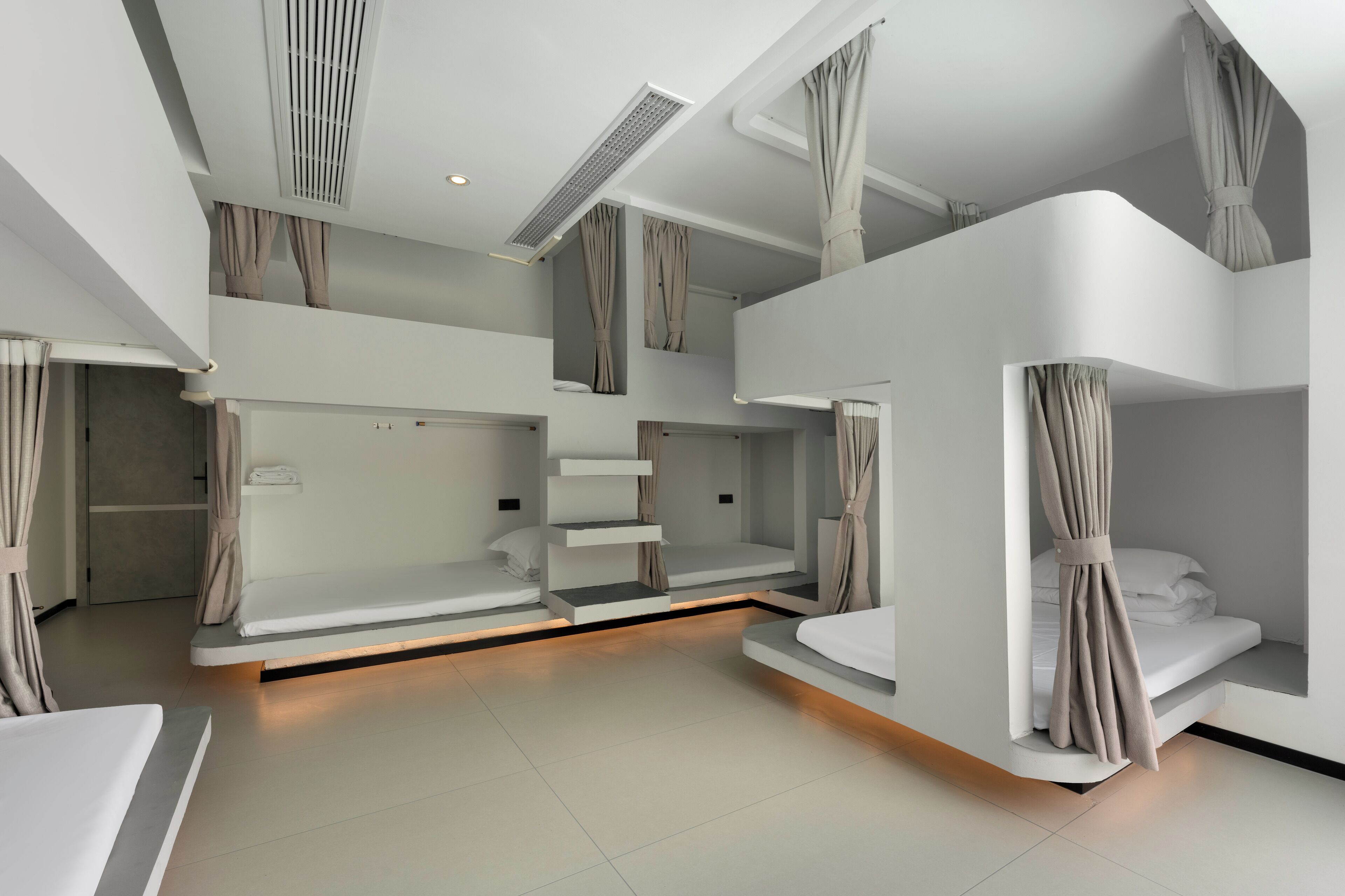 Una habitación de hotel moderna con literas, estantes empotrados y un tragaluz.