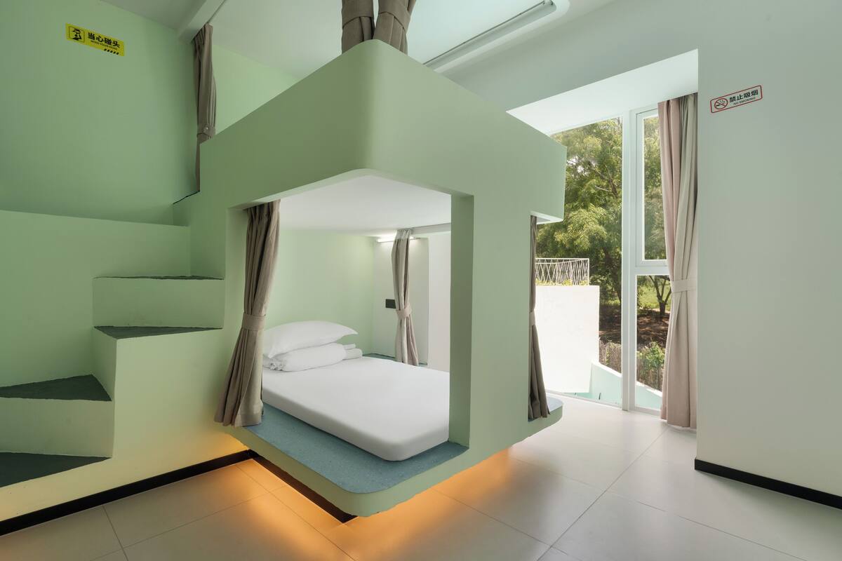 A bunk bed room with a view of greenery outside.