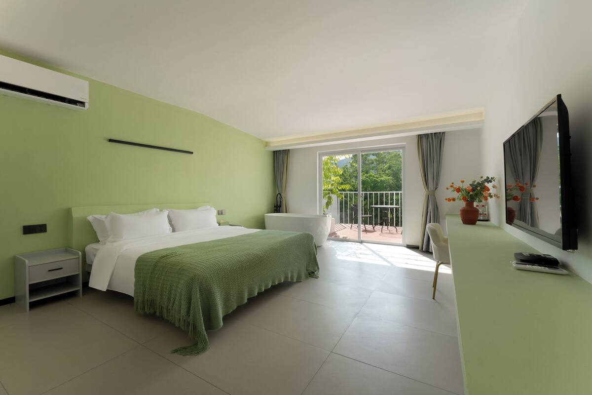 A bedroom with a bed, bedside table, and a TV.