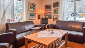 A cozy living room with a brown leather sofa, a wooden coffee table, and a fireplace. - Awesome home in Skillingaryd with WiFi (Skillingaryd)