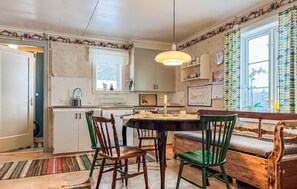 A cozy kitchen with a dining table, chairs, and a window with curtains. - Awesome home in Skillingaryd with WiFi (Skillingaryd)