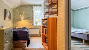 A compact bedroom with a bed, a dresser, a bookshelf, and a window with a view. - Awesome home in Skillingaryd with WiFi (Skillingaryd)
