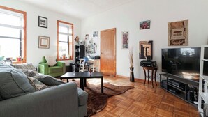 Ett vardagsrum med en soffa, ett soffbord, en tv och en öppen spis.