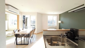 Une cuisine moderne équipée d’un évier, d’une cuisinière et d’un coin repas avec une table et des chaises.