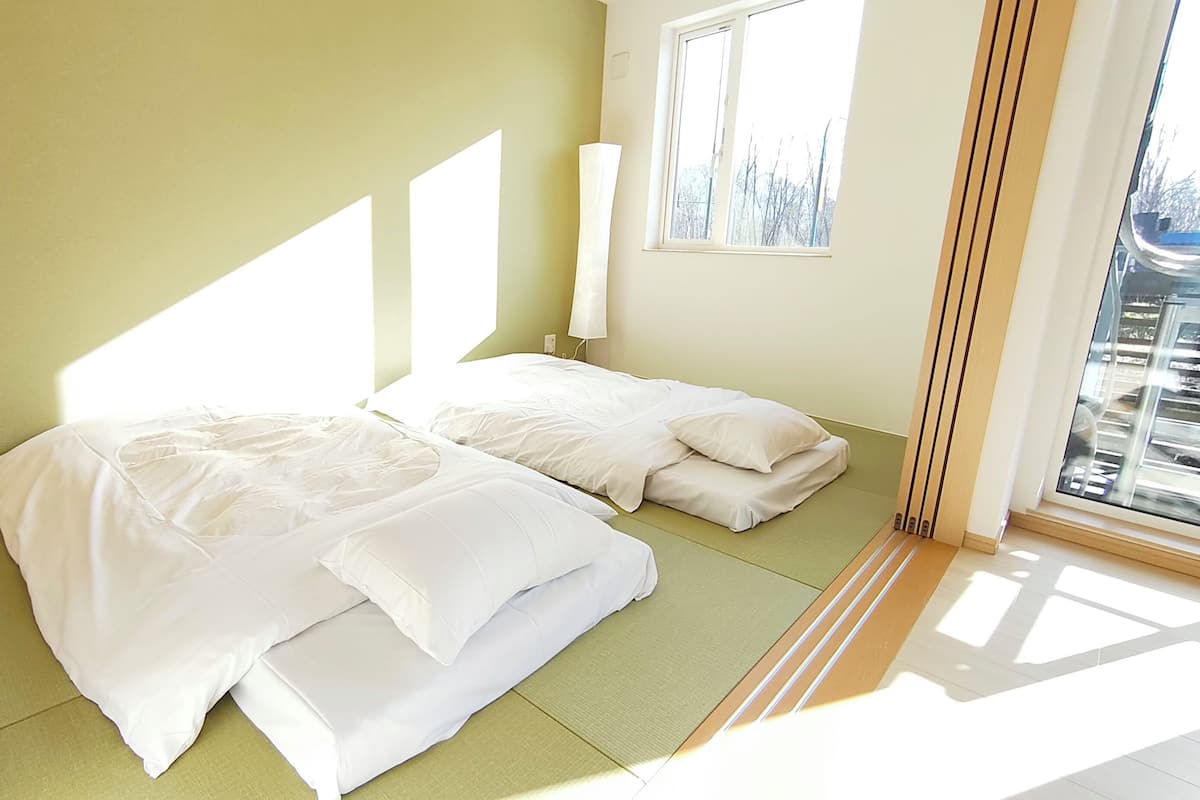 Una habitación con cama, ventana y vistas al exterior.