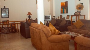 A living room with two brown sofas, a coffee table, and a television. - House of Leisure Holiday Bungalow  (Nuwara Eliya)